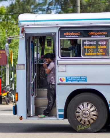 If I had to choose my best street photo, this would be it. A Bus Conductor lighting a cigarette while the bus is under way, the driver is also visible. Galle, Sri Lanka.