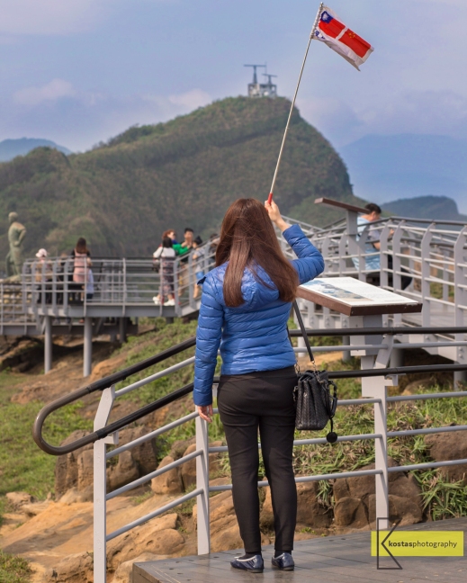 Tour Guide signaling her group in Yehliu Geopark, Taiwan.