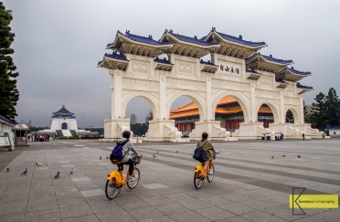 Tourists passing by the gate of Chiang Kaishek Memorial Hall. In Taiwan there are many locations where your can rent a bike, it's great to experience Taipei on a bike tour!
