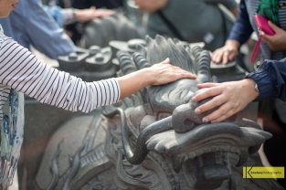 Visitors touching the Lion Statue for good luck outside Dragon and Tiger Pagodas in Kaohsiung.